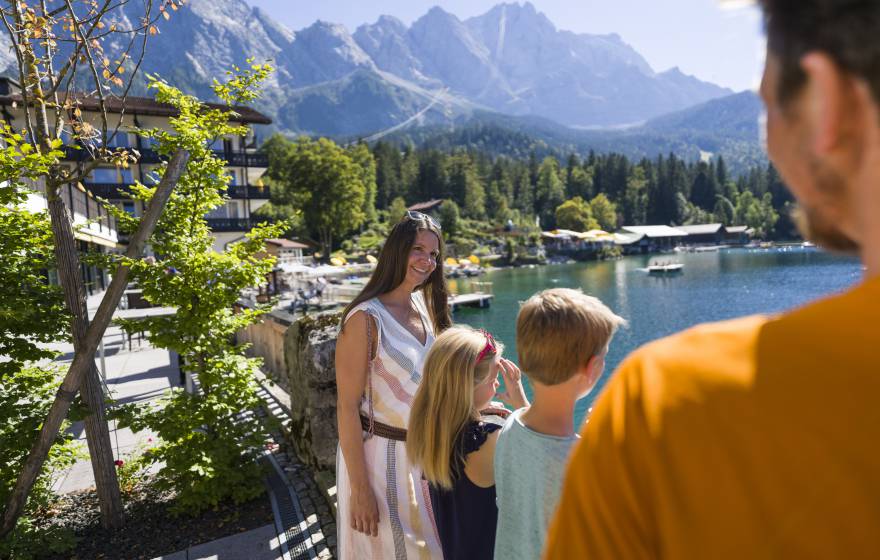 Familie steht auf Brücke mit Blick auf den Eibsee & die Zugspitze